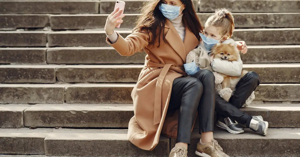 Woman and child wearing face masks taking selfie outdoors with a small fluffy dog, pet safety