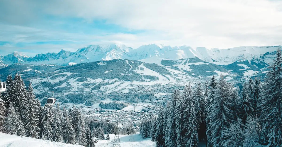 Snowy mountain landscape with ski lifts, pine trees, and a village in winter